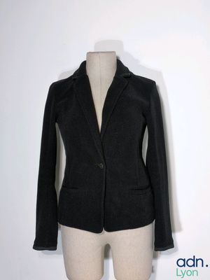 un blazer noir sur un mannequin, sur fond blanc