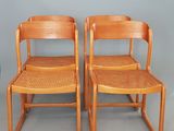 deux chaises en bois avec des assises tressées, adossées à un mur gris