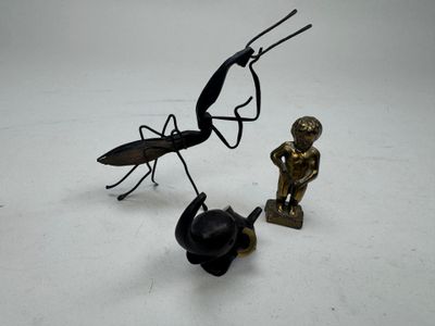 une statue représentant un homme et un insecte sur une surface blanche