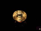 a close up of a yellow diamond on a black surface