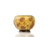 un vase jaune et marron posé sur une table blanche