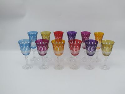 six different colored wine glasses lined up on a white surface