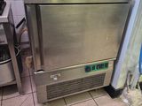 a stainless steel refrigerator in a kitchen with a coffee maker on top of it
