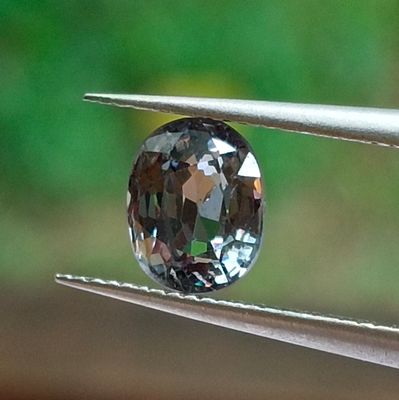 a close up of a diamond being held by a pair of pliers