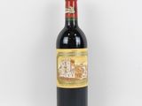 une bouteille de vin rouge posée sur une table blanche