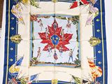 a blue and white square scarf with a red flower on it
