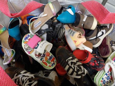 many pairs of shoes in a bag on the floor