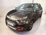 Une voiture noire est garée dans une pièce au sol blanc.