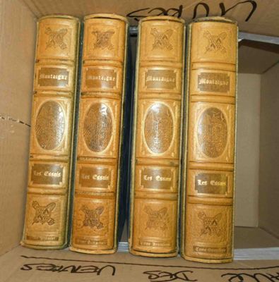 trois livres dans une boîte en carton sur laquelle figurent des inscriptions