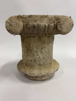 un gros plan d'un socle en pierre posé sur une surface blanche