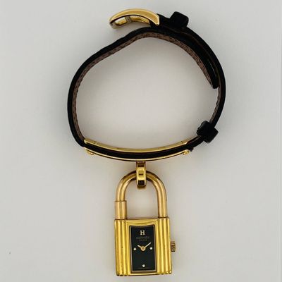 a black and gold watch with a padlock attached to it