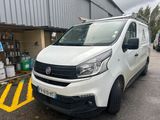 la camionnette blanche est garée devant un bâtiment dans un parking