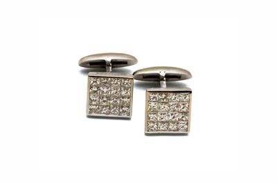 une paire de boutons de manchette en diamant sur fond blanc