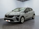Une voiture grise est garée dans une pièce aux murs blancs.
