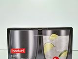 photo de deux verres contenant des citrons verts et des glaçons, posés sur une table