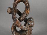 two wooden sculptures of a snake and a snake on a table