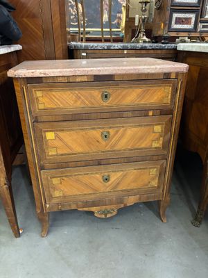 une petite commode dans le coin d'une pièce