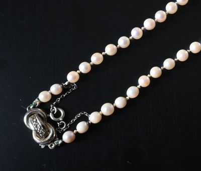 gros plan d'un collier de perles sur une surface noire