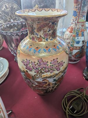 many vases and plates on a table with a red table cloth