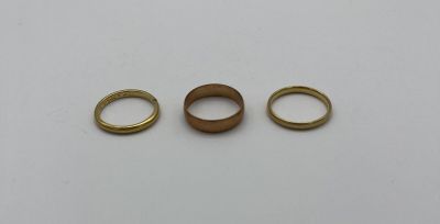 trois anneaux en laiton sur un fond blanc