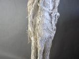 sculpture of a man standing on a rock with a white cloth covering his body