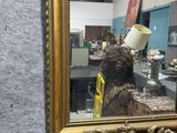 a gold framed mirror hanging on a wall in a room