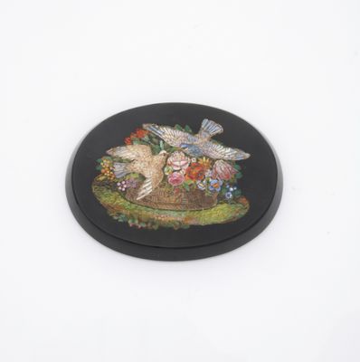 une image représentant une assiette noire ornée d'un oiseau et de fleurs