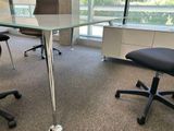 des tables et des chaises dans un bureau avec vue sur l'extérieur