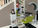 a picture of a salon room with a chair and a desk