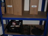 boxes are stacked on a blue shelf in a room