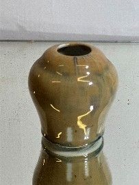 un petit vase posé sur une table en verre