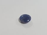 a close up of a blue sapphire stone on a white surface