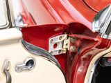 a close up of a red and white car with a door handle