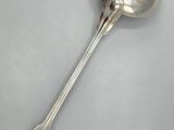 a silver spoon with a spoon handle on a white surface