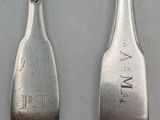 two spoons that are sitting next to each other on a table