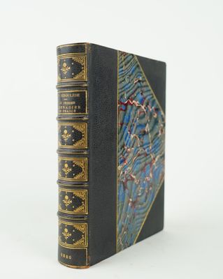 un vieux livre noir aux bords dorés et à la couverture bleue