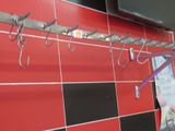 un mur recouvert de carreaux rouges sur lequel sont fixés plusieurs crochets