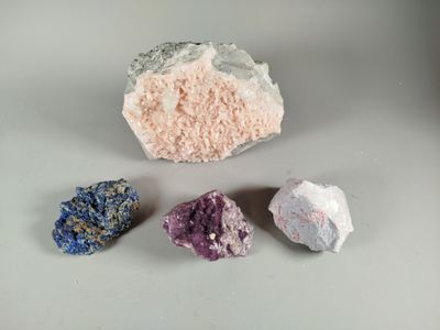 three different colored rocks sitting on top of a white surface