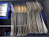 a lot of forks and spoons in a blue box