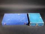 two old suitcases sitting side by side on a black surface