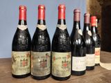 several bottles of wine are lined up on a wooden table
