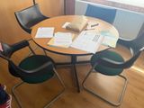 a table with chairs and papers on it in a room