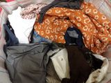 a basket full of clothes sitting on a bed