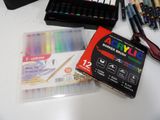 a box of markers and a box of pens on a table