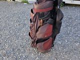 un sac de clubs de golf posé par terre à côté d'un conteneur