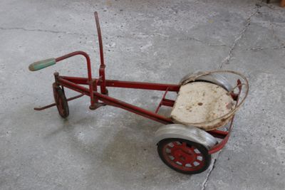a small red tricycle with a basket on the back