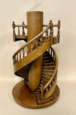 a wooden sculpture of a spiral staircase on a pedestal
