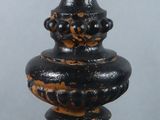 a close up of a black and gold vase on a table