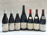 six bottles of wine are lined up in a row on a white surface