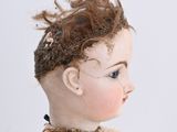 a doll that is sitting on a white surface